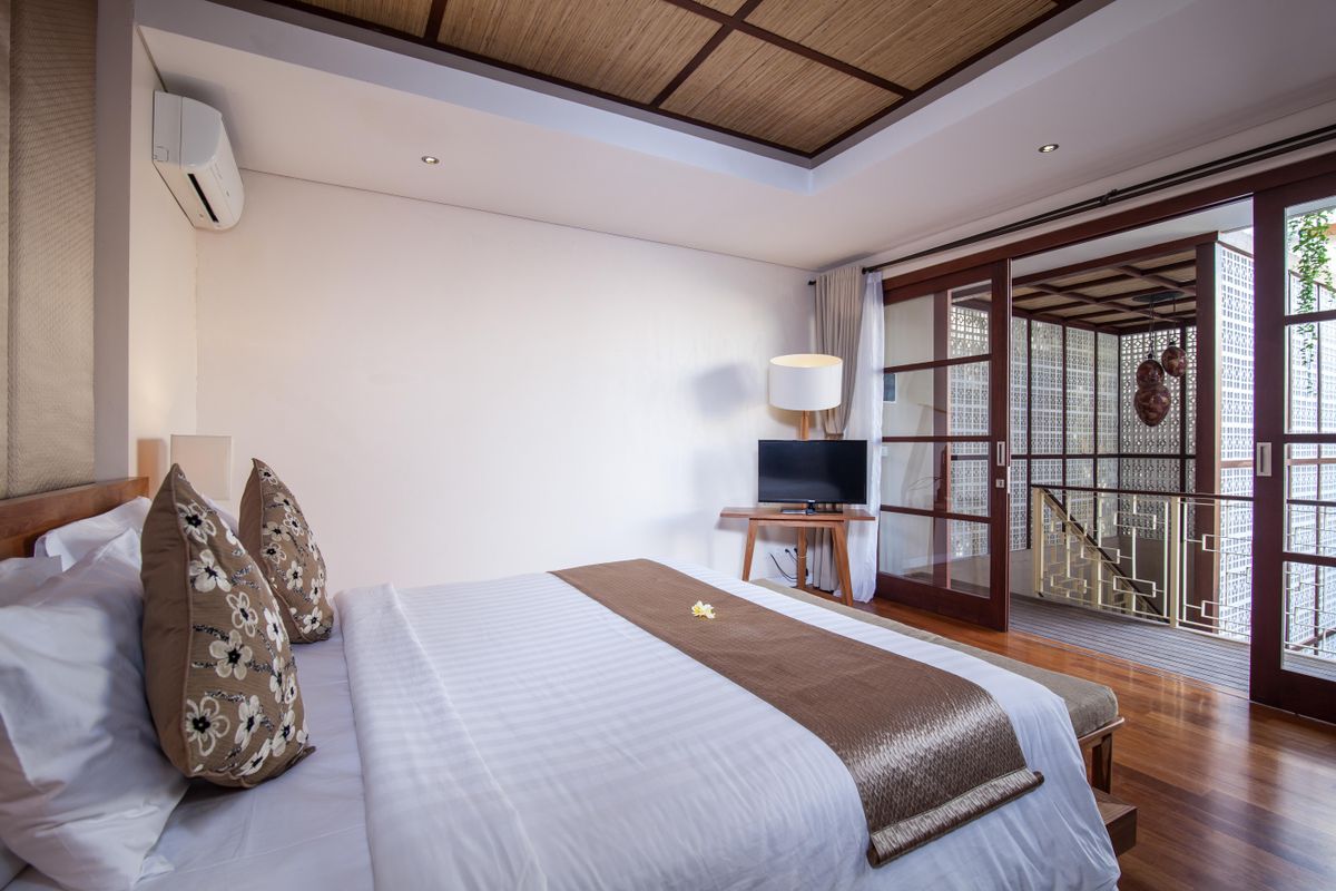 A serene villa bedroom in crisp white linen
